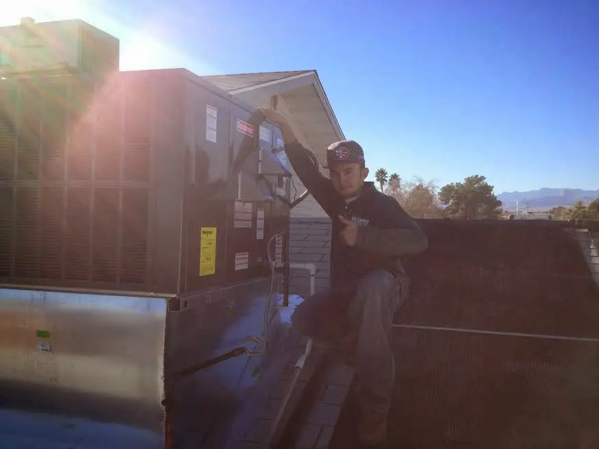 HVAC technician performing AC Tune-Up on a rooftop unit in Naples Manor